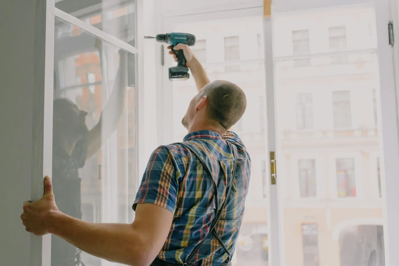 Handyman drilling into a wall to mount a bracket